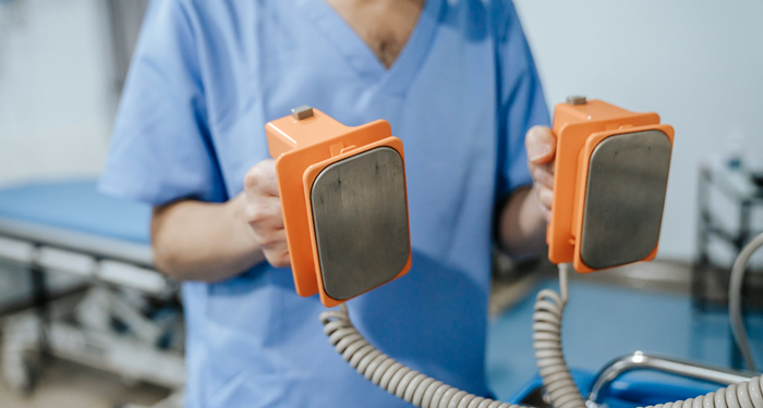 What is a defibrillator and how does it help restore heart rhythm?